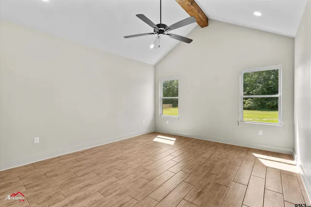 an empty room with windows and fan