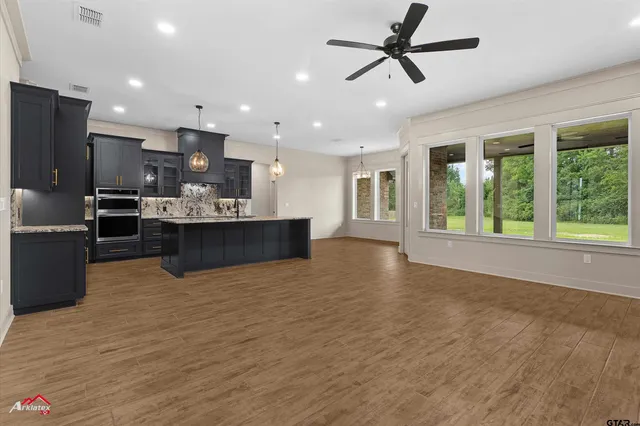 a view of kitchen with stainless steel appliances granite countertop a stove and a refrigerator