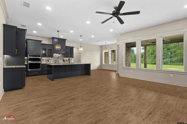a large kitchen with granite countertop a large counter top space appliances and cabinets