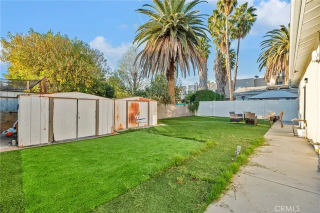 a view of a backyard with table and chairs under an umbrella
