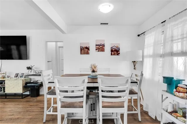 a view of a dining room with furniture a kitchen and chandelier