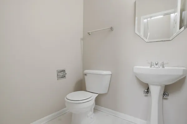 a bathroom with a toilet a sink and mirror
