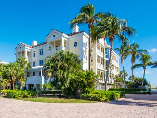 a front view of multi story residential apartment building with yard and sign board