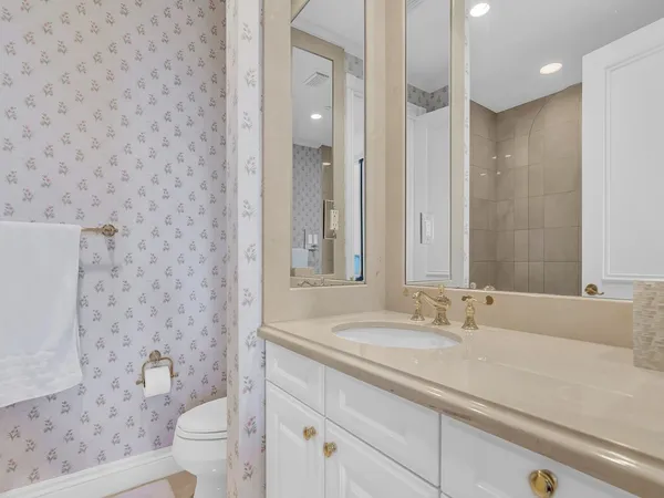 a bathroom with a sink a toilet a shower and a mirror