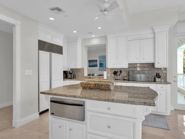 a kitchen with granite countertop white cabinets and stainless steel appliances