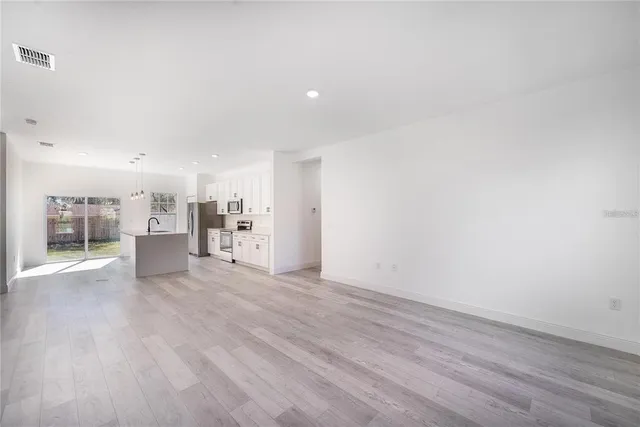 a view of a kitchen with a sink and wooden floor