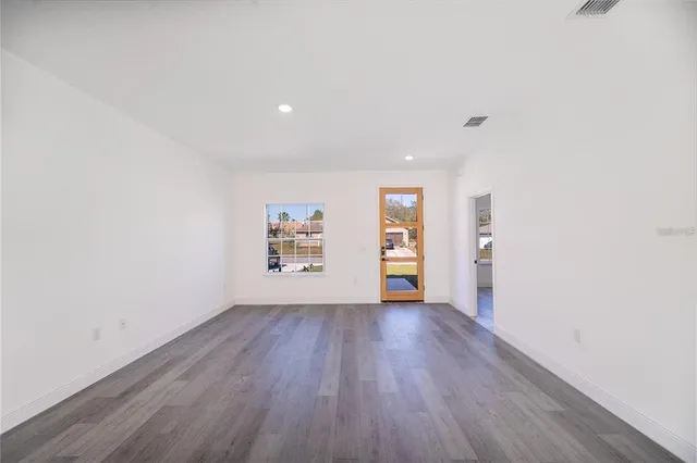 a large kitchen with cabinets and wooden floor
