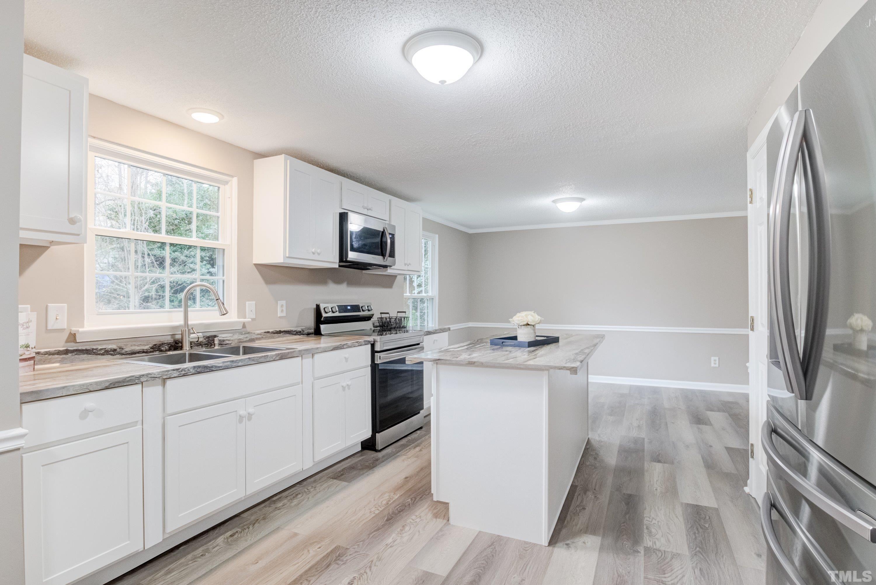 1012 Ironstone Court Raleigh, NC 27615 - Photo 6 of 41 a kitchen with stainless steel appliances a sink stove and refrigerator