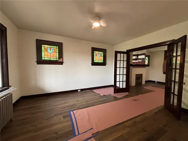 a view of a livingroom with wooden floor and a ceiling fan