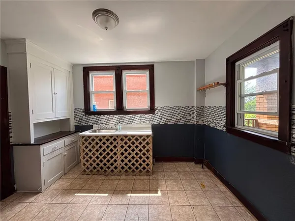 a hallway with white walls and next to a window