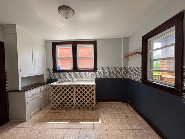 a hallway with white walls and next to a window