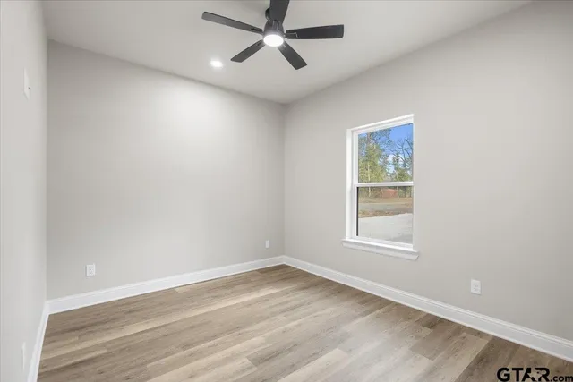 an empty room with a window and a fan