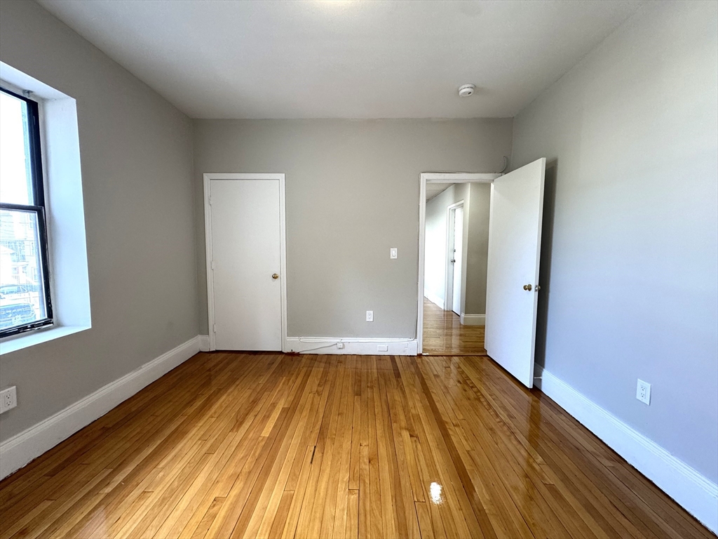 8 Langmaid Avenue, Unit 4 Somerville, MA 02145 - Photo 2 of 8 a view of an empty room with wooden floor and a window