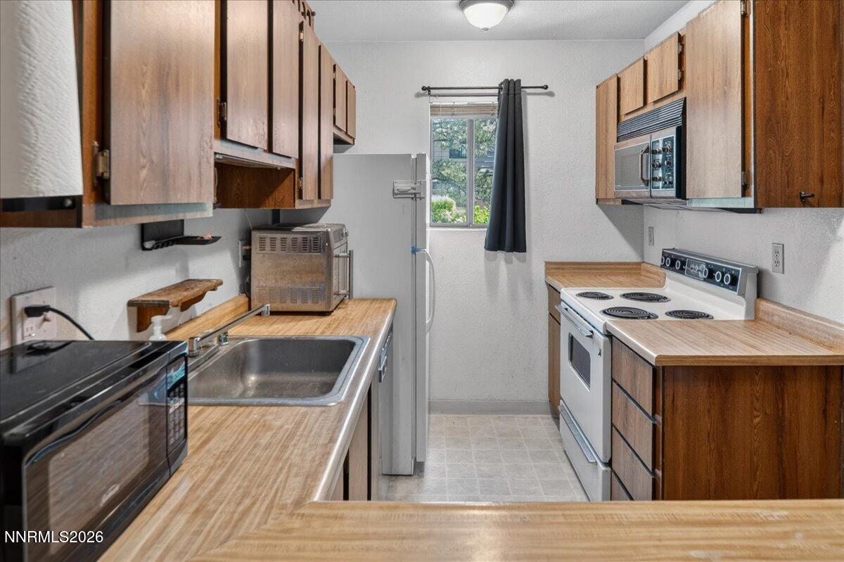 4380 Matich Drive Reno, NV 89502 - Photo 4 of 21 a kitchen with stainless steel appliances granite countertop a sink stove and refrigerator