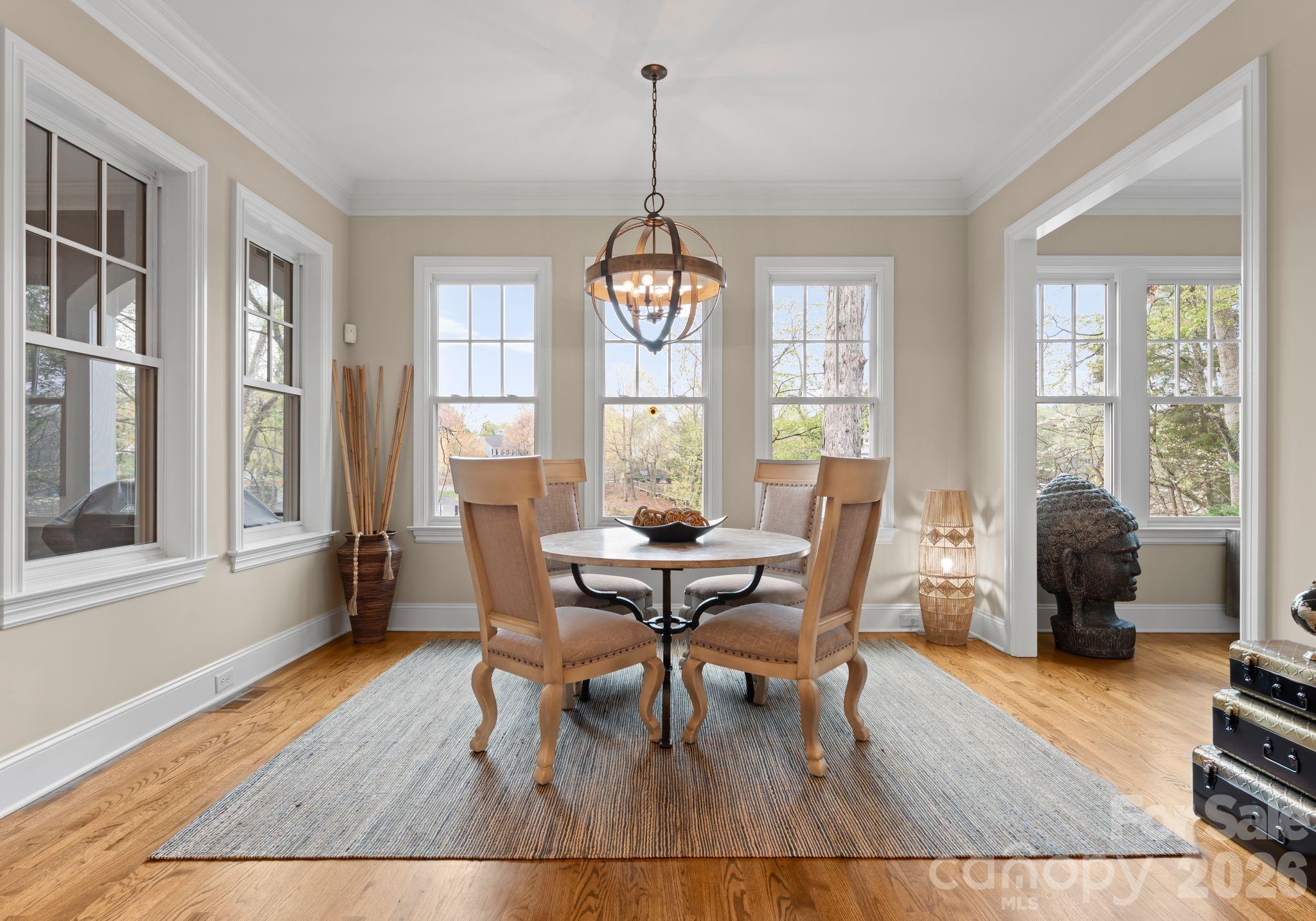 21311 Baltic Drive Cornelius, NC 28031 - Photo 11 of 39 a dining room with wooden floor a chandelier a glass table and chairs