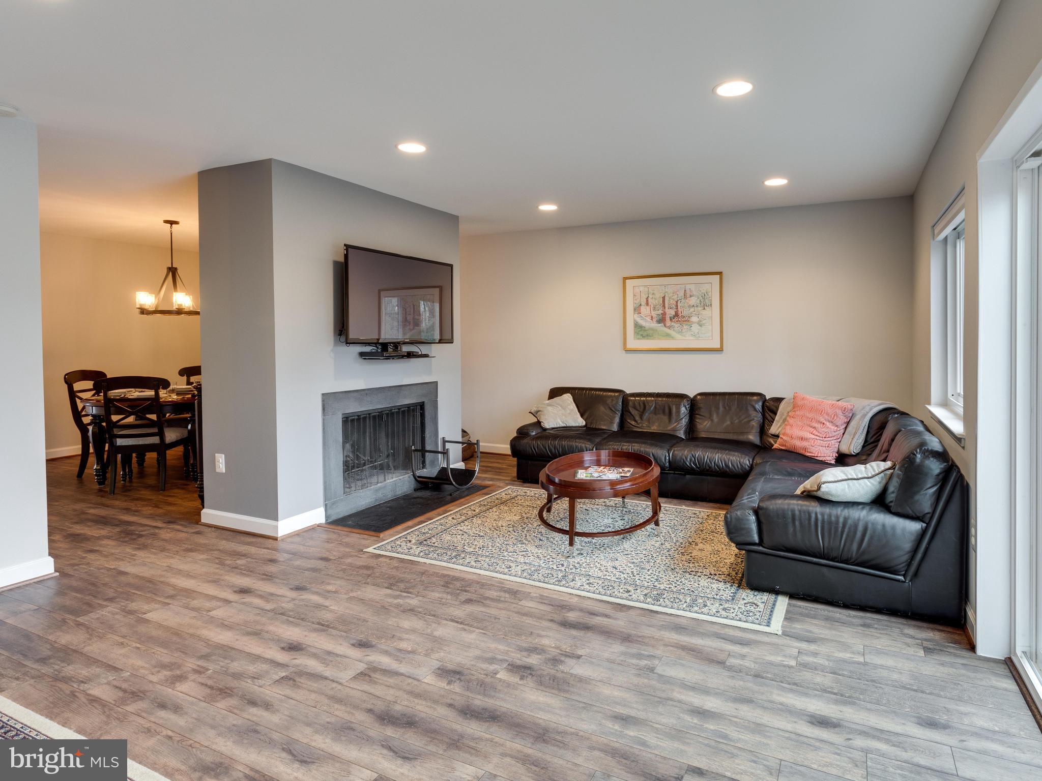 1663 Bachan Court Reston, VA 20190 - Photo 12 of 29 a living room with furniture a fireplace and a flat screen tv