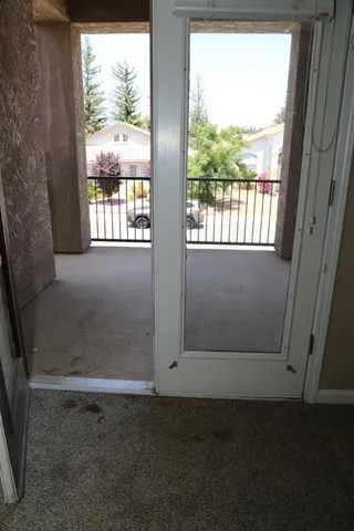 a view of a room with a hanging light and hardwood floor