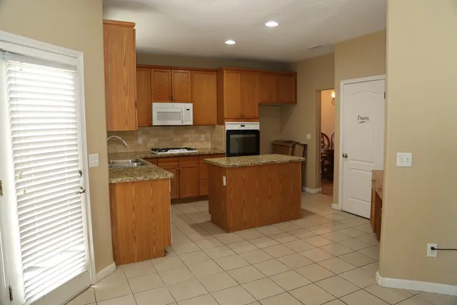 a kitchen with granite countertop a sink and cabinets