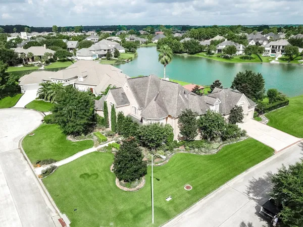 an aerial view of a house with a garden and lake view