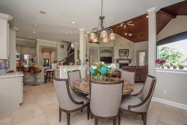 a dining room with furniture a rug a potted plant and a chandelier