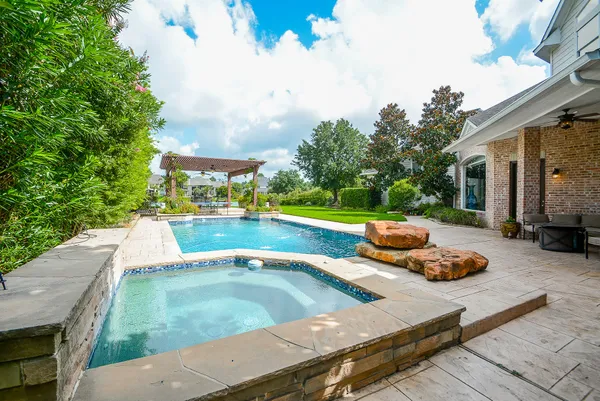 a view of a swimming pool with a patio and a garden
