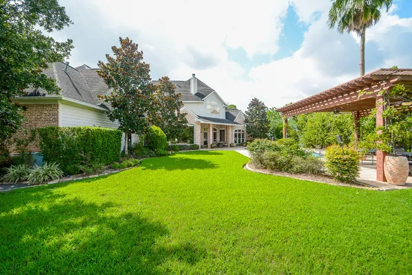 a view of an house with backyard and a tree
