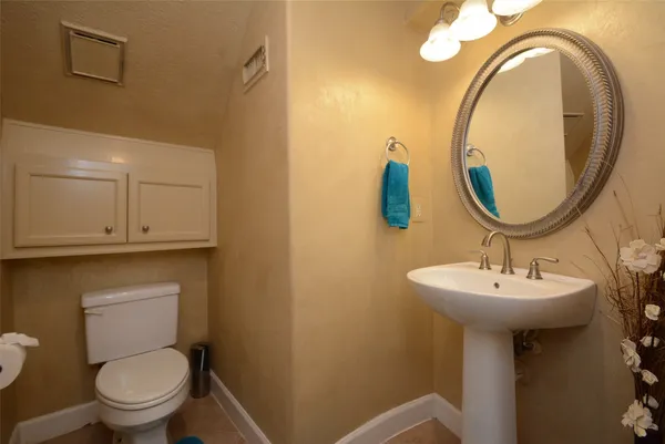 a bathroom with a toilet sink and mirror