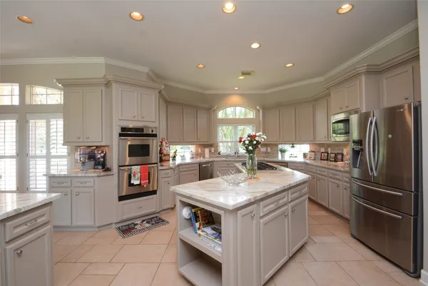 a kitchen with kitchen island granite countertop a sink counter top space appliances and cabinets