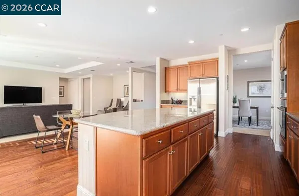 a kitchen with stainless steel appliances sink stove refrigerator and wooden floor