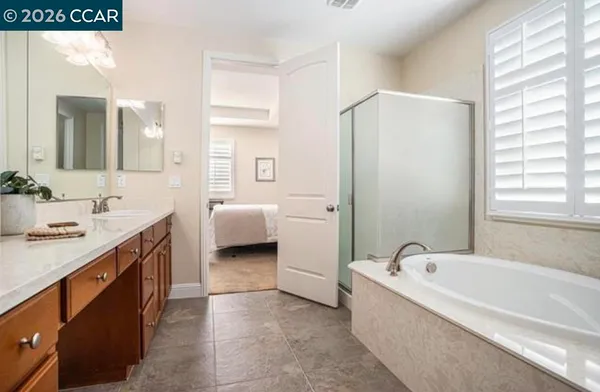 a spacious bathroom with a tub sink double vanity and mirror