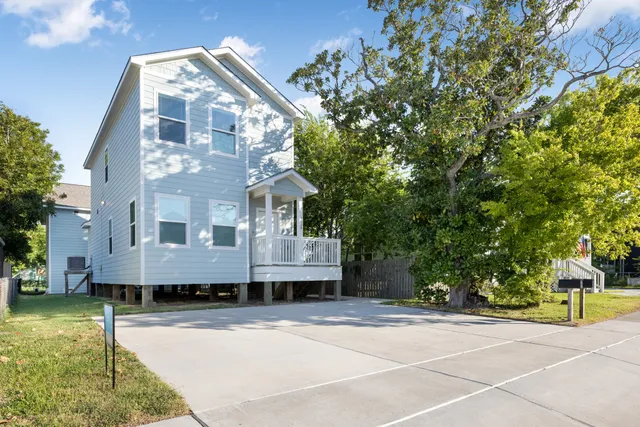 a view of a house with a yard and large tree