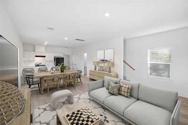 a living room with furniture kitchen view and a window