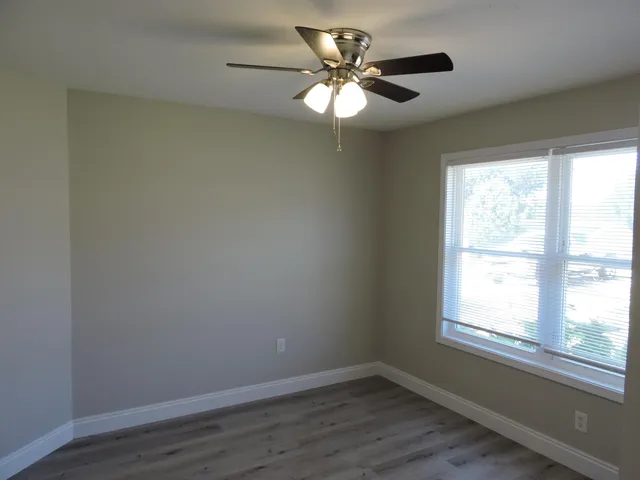an empty room with a window and wooden floor