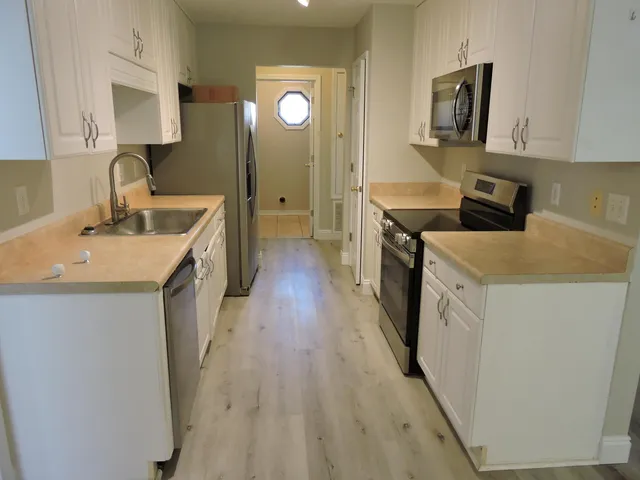 a kitchen with a sink stove and cabinets