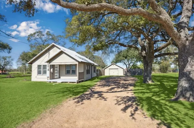 a front view of a house with a yard and trees