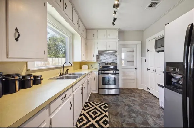 a kitchen with stainless steel appliances a stove sink and refrigerator