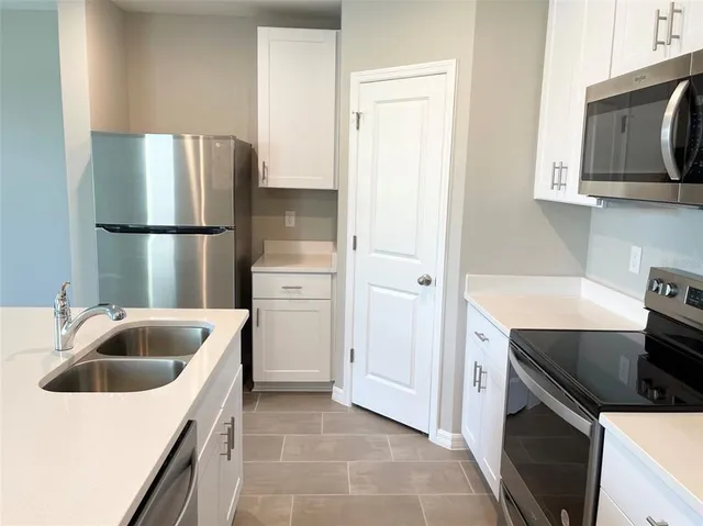 a kitchen with a sink a refrigerator and cabinets