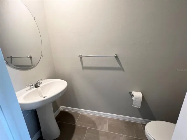 a bathroom with a sink mirror and toilet
