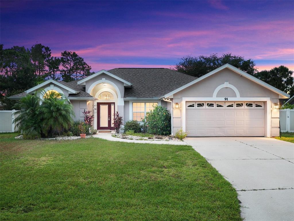91 Fenimore Lane Palm Coast, FL 32137 - Photo 1 of 1 a front view of a house with a yard and garage