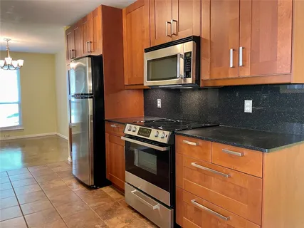 a kitchen with granite countertop a refrigerator stove and microwave
