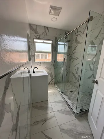 a bathroom with a sink a mirror and a shower