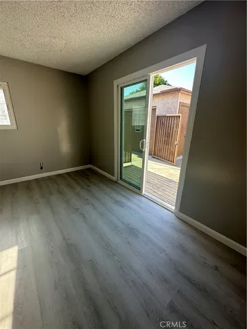 an empty room with wooden floor and a door