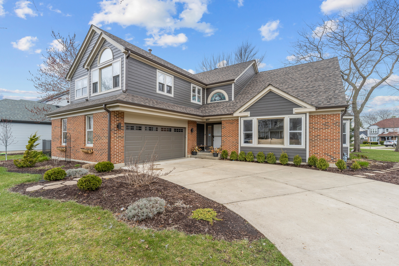 a front view of a house with a garden and plants