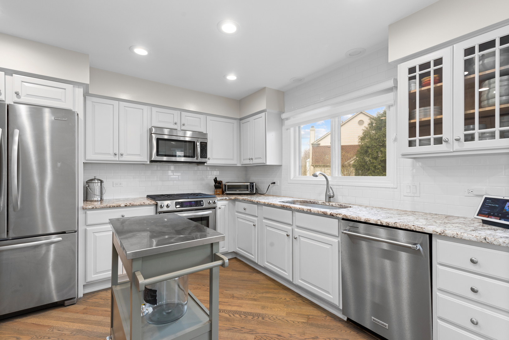 607 Raintree Road Buffalo Grove, IL 60089 - Photo 10 of 27 a kitchen with white cabinets and stainless steel appliances