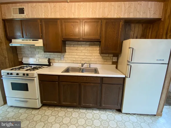 a stove top oven sitting inside of a kitchen