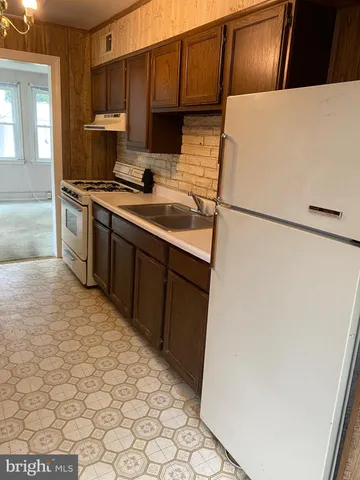 a kitchen with stainless steel appliances a refrigerator sink and cabinets