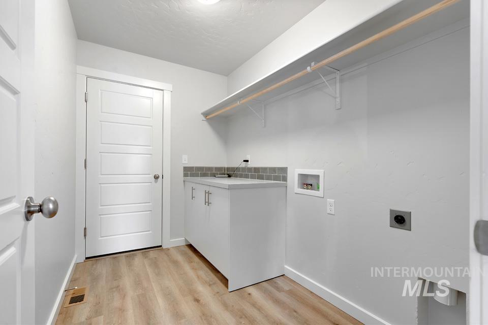 1340 Dawn Street Weiser, ID 83672 - Photo 12 of 32 Washroom with light wood-style flooring, washer hookup, and electric dryer hookup
