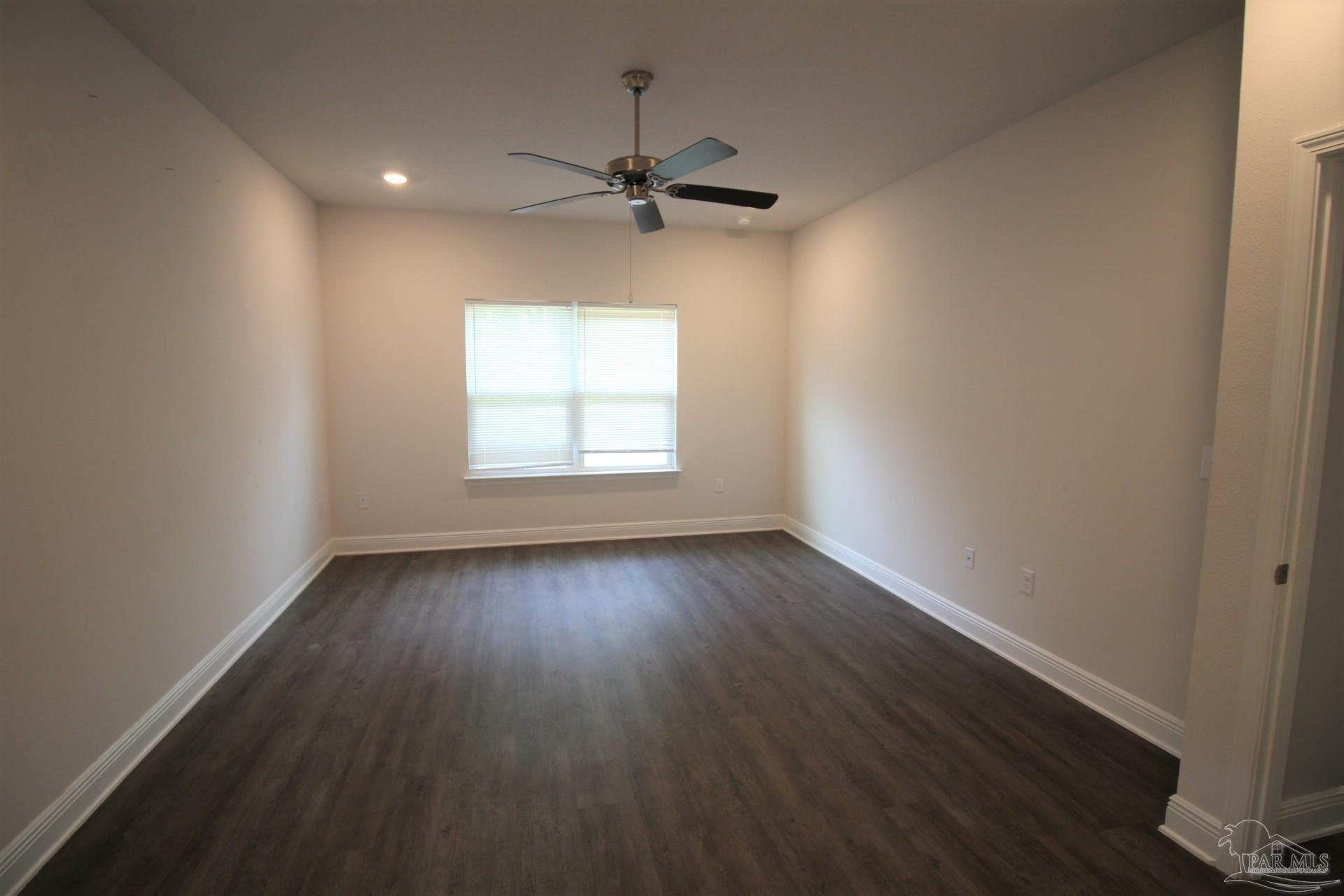8006 Burnside Loop Pensacola, FL 32526 - Photo 12 of 22 an empty room with wooden floor fan and windows