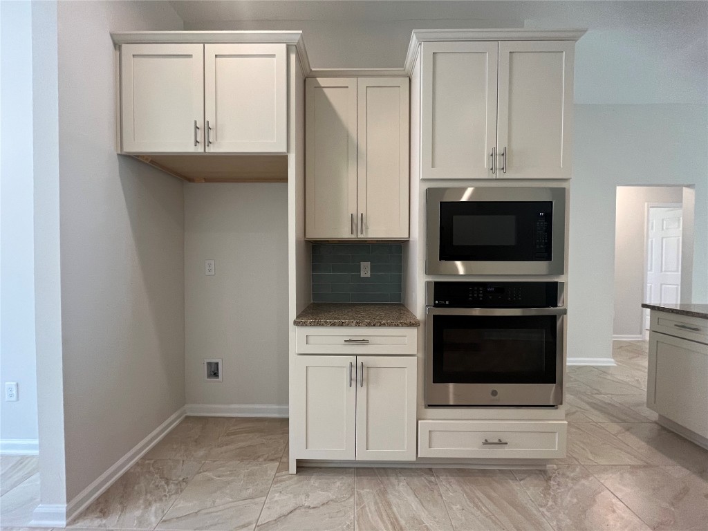 96754 Quartz Lane Yulee, FL 32097 - Photo 11 of 23 a kitchen with stainless steel appliances a stove a microwave and a white cabinet