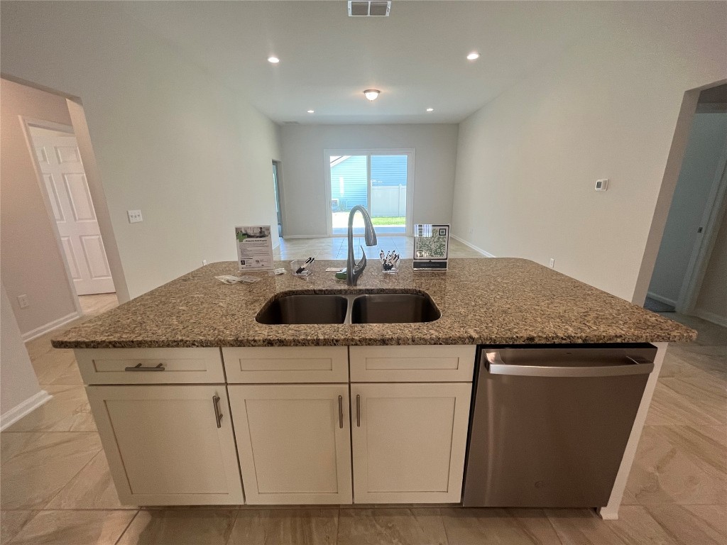 96754 Quartz Lane Yulee, FL 32097 - Photo 13 of 23 a kitchen with kitchen island granite countertop a sink and white cabinets